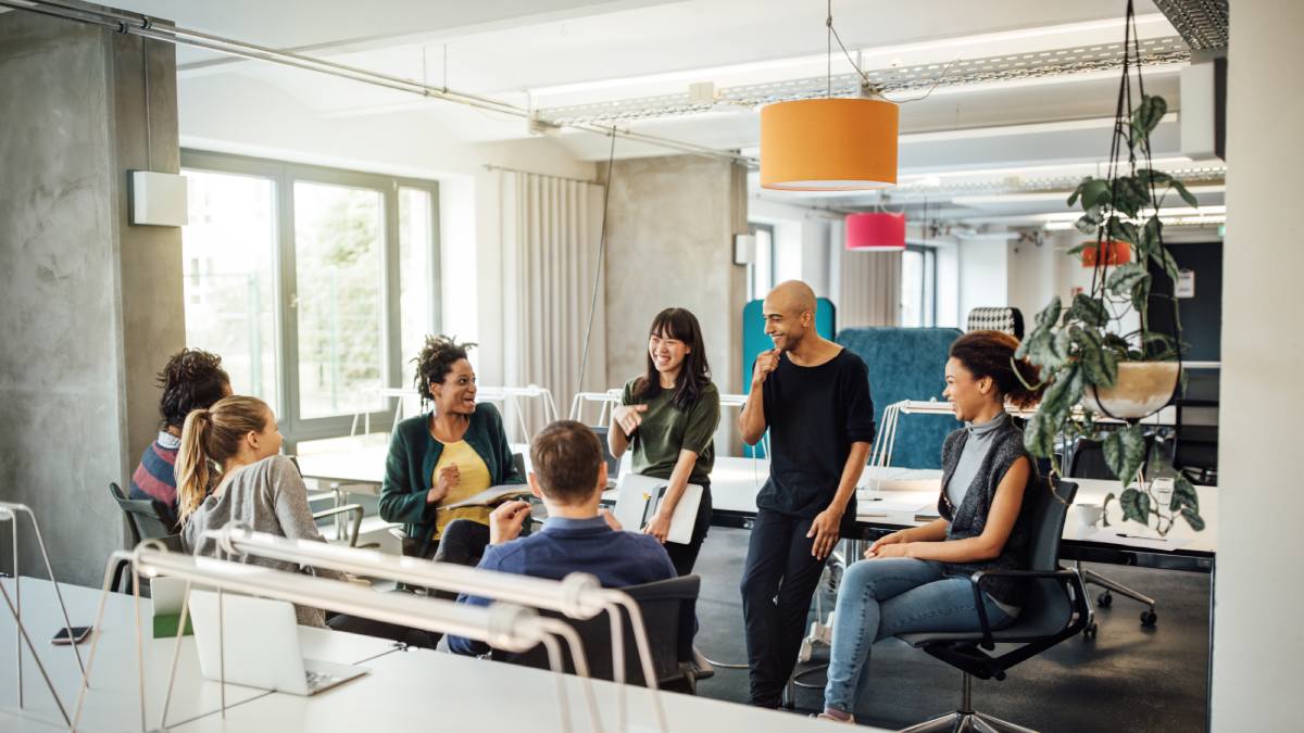 Group of professionals mix of ages sat in a circle in an office environment having a conversation