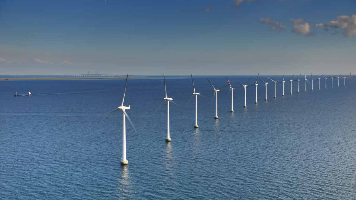 line of white wind turbines in the sea