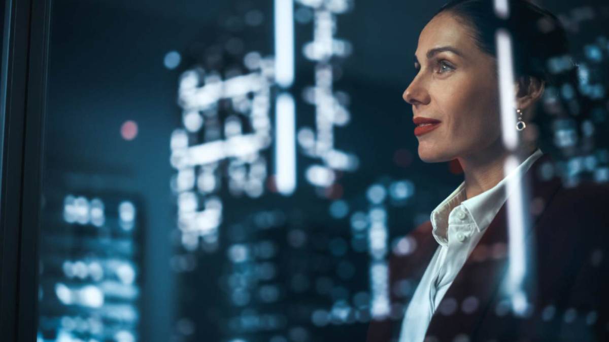 Close up of a business woman in corporate looking building in a city looking out the window