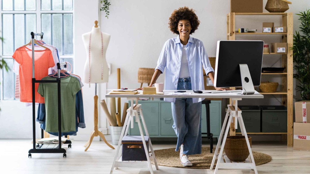 Young black woman stood behind a counter in a small independent shop