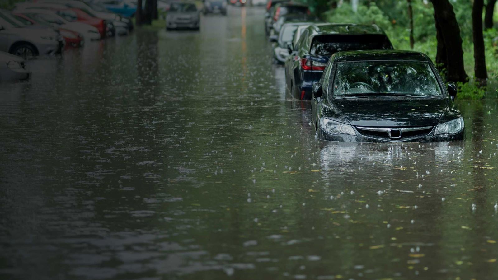 cars on a UK street half submerged in flood water from rain and storms